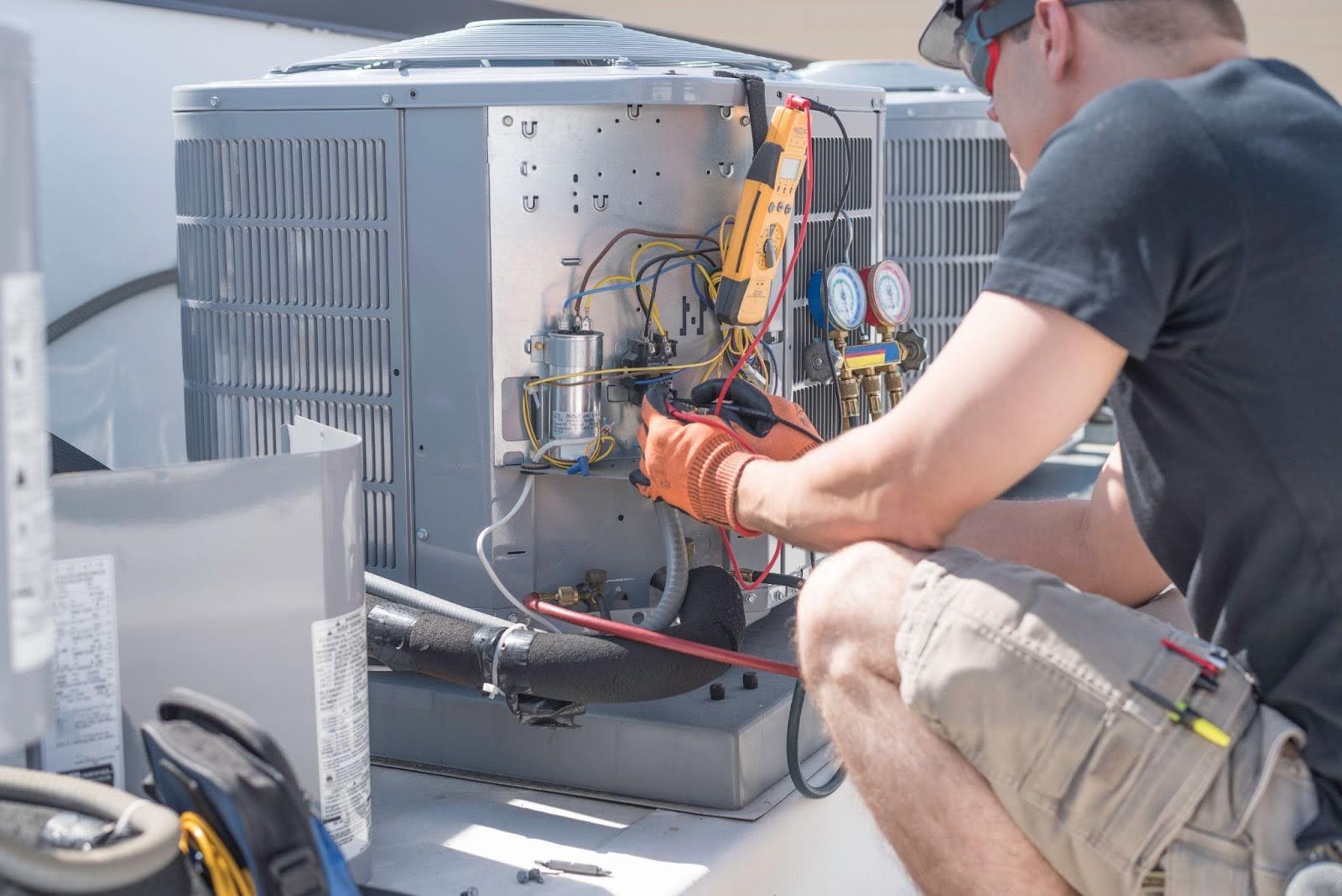 A man diligently servicing an air conditioning unit, showcasing expertise in HVAC maintenance