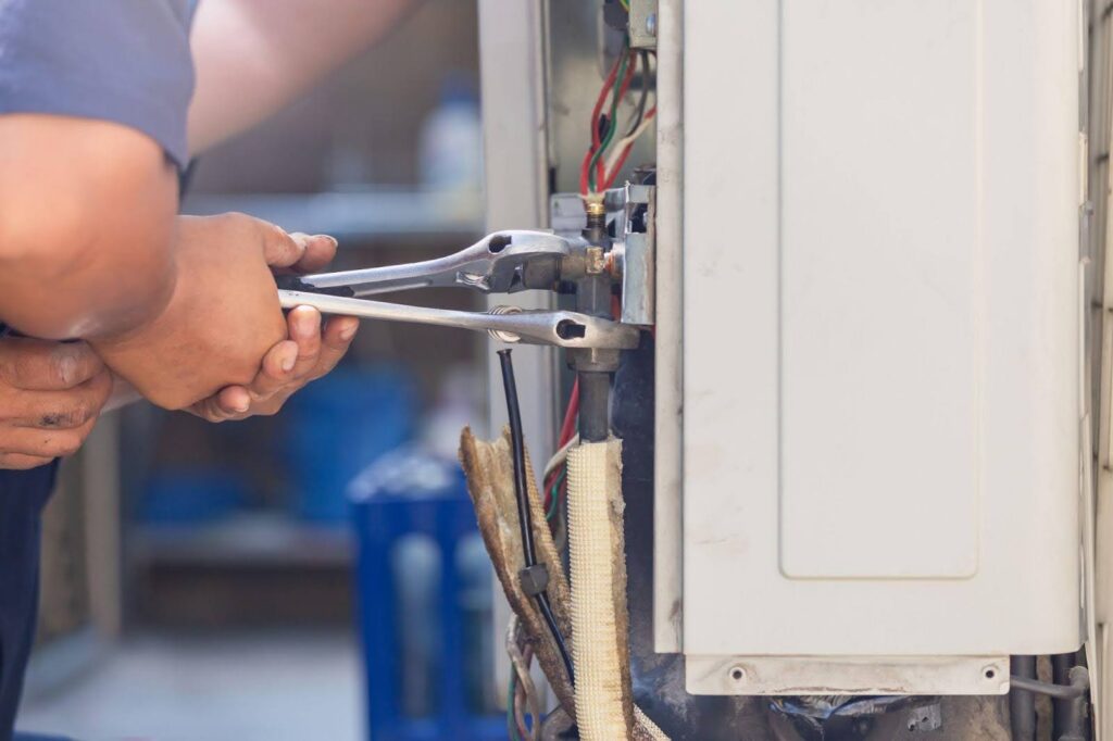 A technician skillfully fixes a water heater with attention to detail